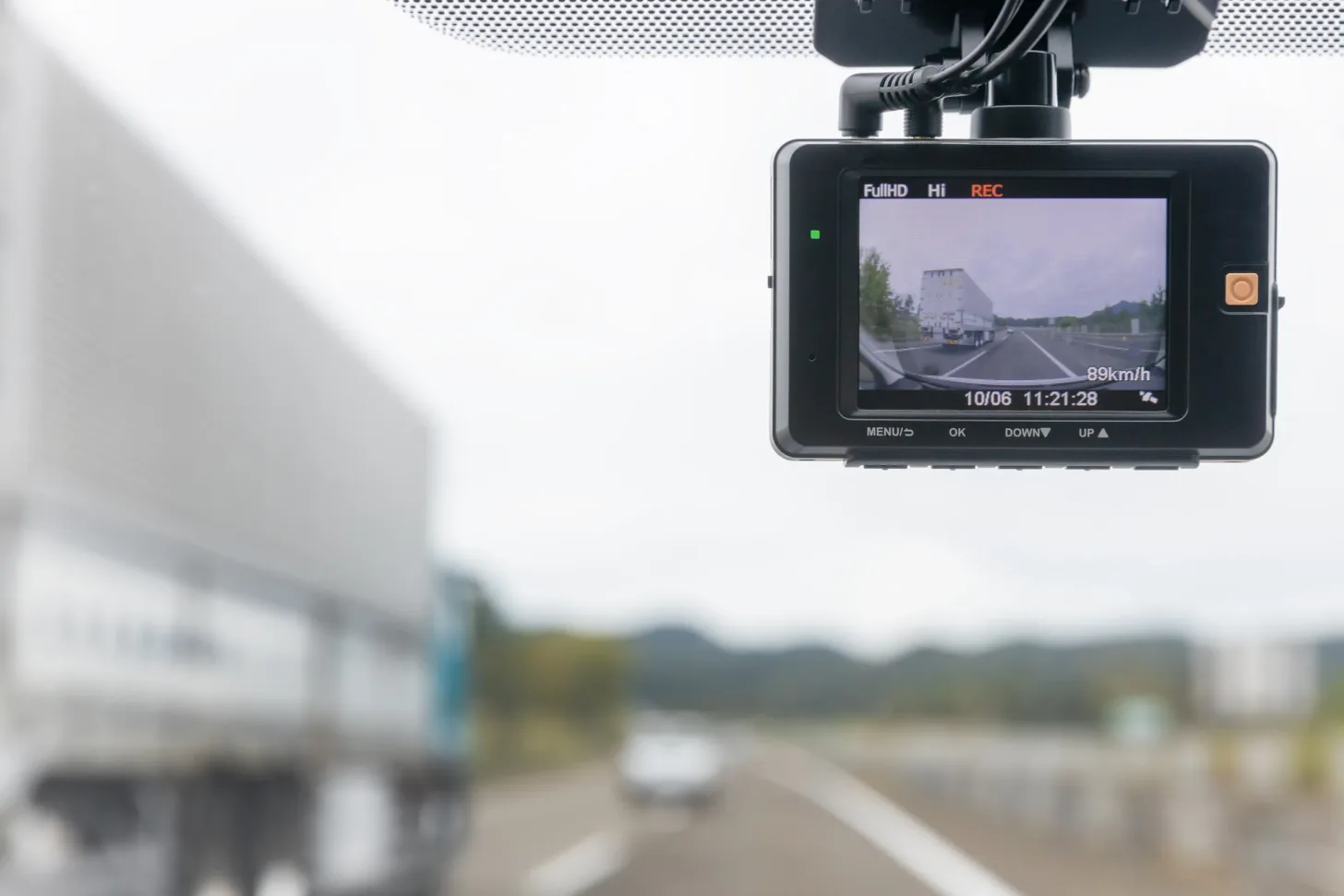 Dash cam montada en el parabrisas grabando la ruta con un camión adelante