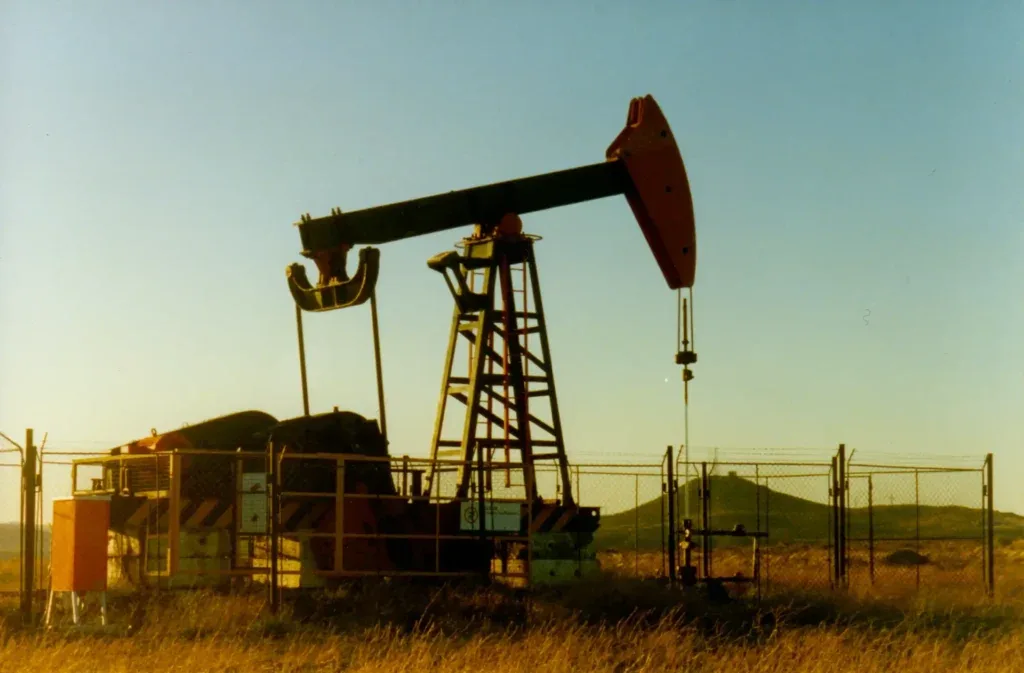 Bomba extractora de petróleo en un yacimiento al atardecer